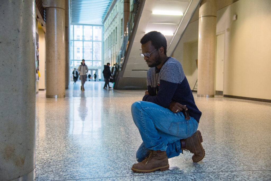 Guy Olivier Musafiri pays his respects at the spot where he saw the student die, nearly three and a half years later.